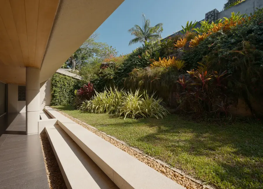 Covered walkway along the planted hillside garden