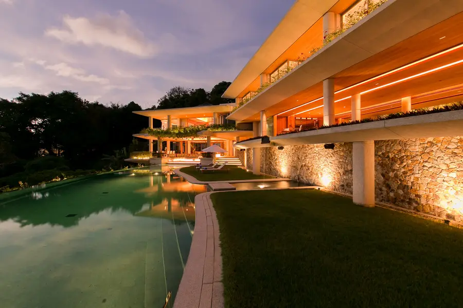 Villa and lawn lit beside the pool in the evening
